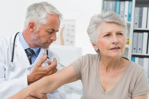 Manliga läkare injicera äldre patient — Stockfoto