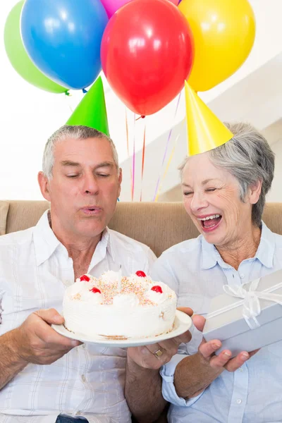 Coppia anziana seduta sul divano per festeggiare un compleanno — Foto Stock