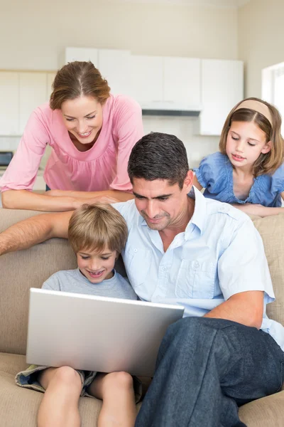 Family using laptop in living room — Stock Photo, Image