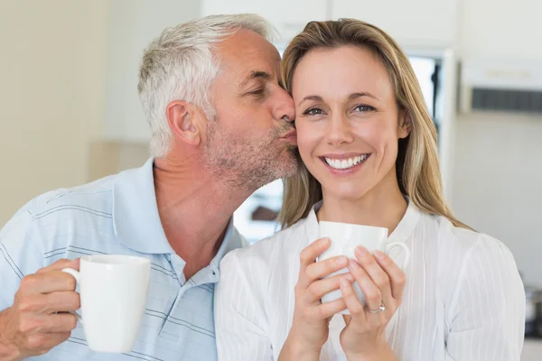 Przypadkowy mężczyzna dając partnerką uśmiechający się buziaka w policzek — Zdjęcie stockowe