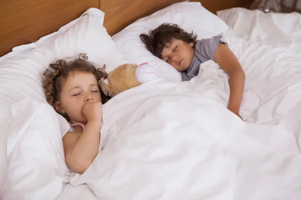 Menina e menino dormindo na cama — Fotografia de Stock