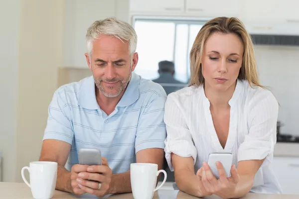 Fernstehendes Paar sitzt am Schalter und schreibt SMS und redet nicht — Stockfoto
