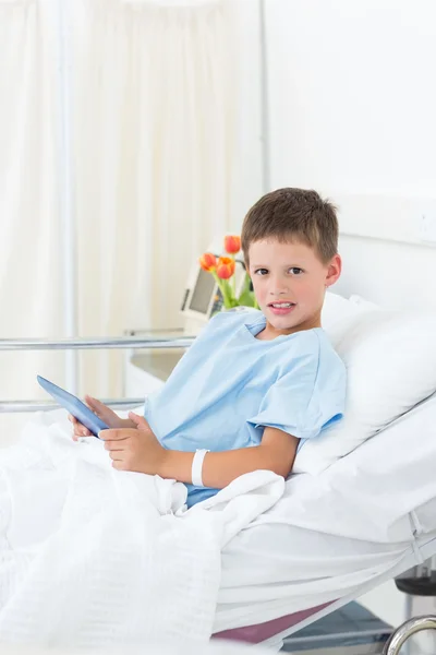Chory chłopiec trzyma cyfrowe tabletki w szpitalu — Zdjęcie stockowe