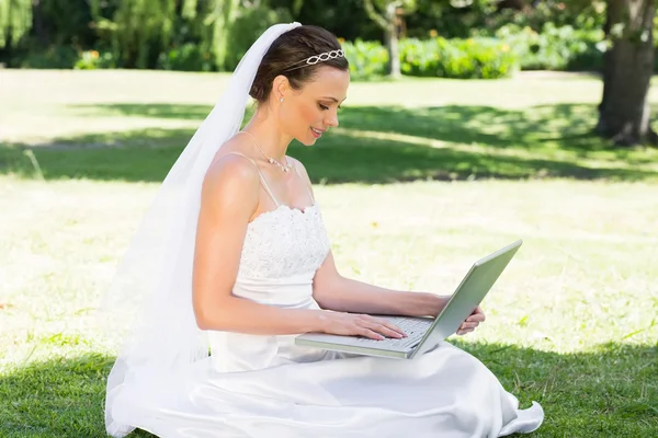 Невеста с ноутбуком в саду — стоковое фото