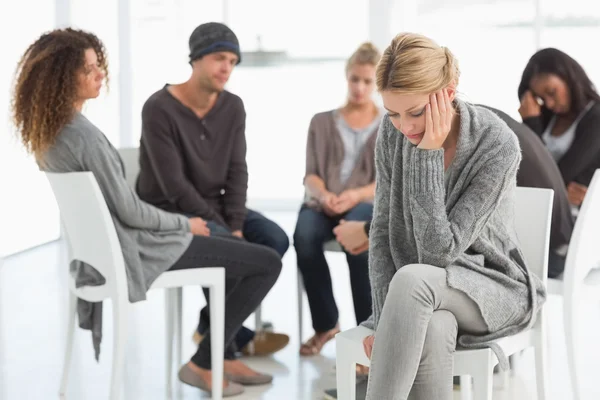 Femme bouleversée avec la tête dans les mains au groupe de réadaptation — Photo