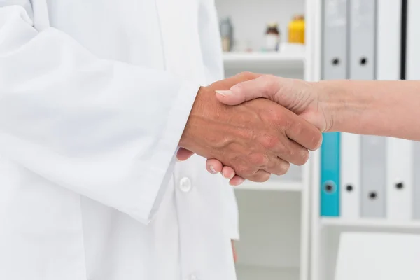 Mitten delen av en läkare som skakar hand med patienten — Stockfoto