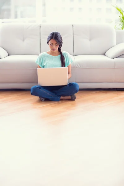 Ragazza seduta su un pavimento utilizzando il computer portatile — Foto Stock