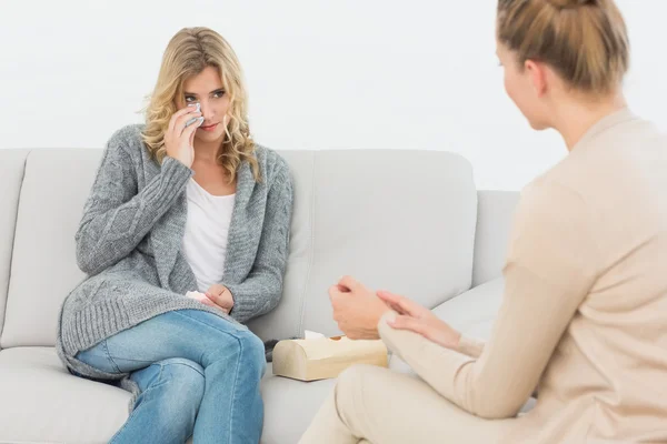 Терапевт разговаривает с плачущим пациентом на диване — стоковое фото