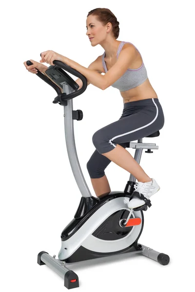 Beautiful woman on stationary bike — Stock Photo, Image