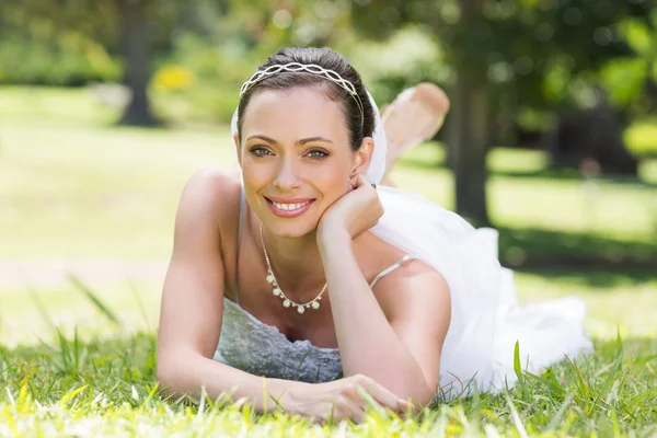Attractive bride relaxing on grass — Stock Photo, Image
