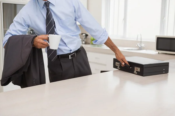 Homem com copo de café colhendo pasta — Fotografia de Stock