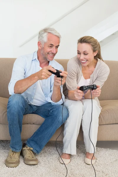 Casal feliz se divertindo no sofá jogando videogames — Fotografia de Stock