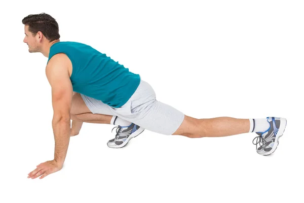 Vista lateral de un hombre en forma haciendo ejercicio de estiramiento —  Fotos de Stock