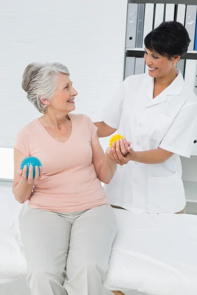 Médico com paciente sênior usando bolas de stress buster — Fotografia de Stock