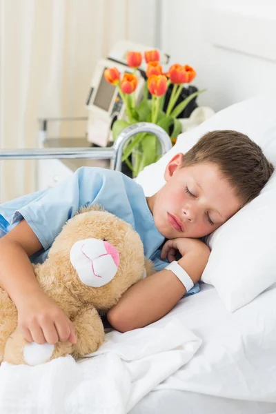 Jongen met teddy bear slapen in het ziekenhuis — Stockfoto