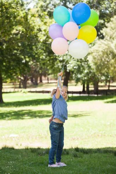 Chica joven con globos de colores en el parque — Foto de Stock