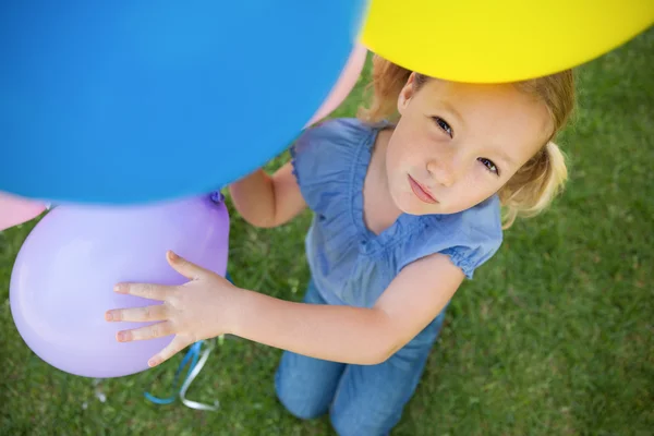 Jong meisje met kleurrijke ballonnen in park — Stockfoto