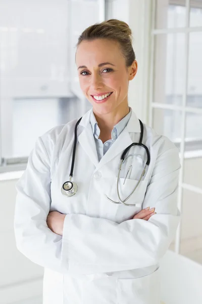 Beautiful female doctor with arms crossed in hospital Stock Image
