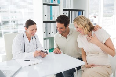 Gynaecologist and expectant couple clipart