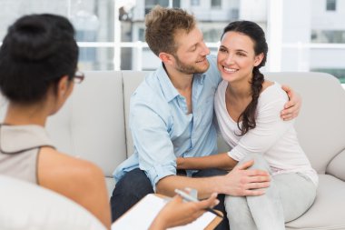 Happy couple reconciling at therapy session clipart