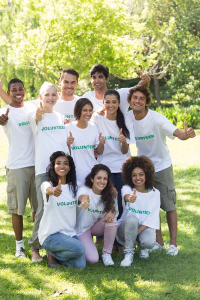 Volunteers showing thumbs up in park — Stock Photo, Image