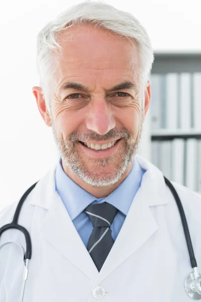 Sonriente médico varón confiado en el consultorio médico —  Fotos de Stock