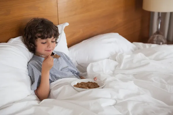 Αγόρι που τρώει πρωινό στο κρεβάτι — Φωτογραφία Αρχείου