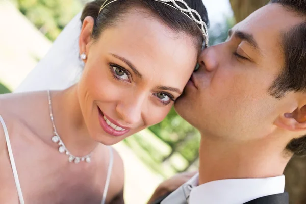 Novia siendo besada por el novio en el jardín — Foto de Stock