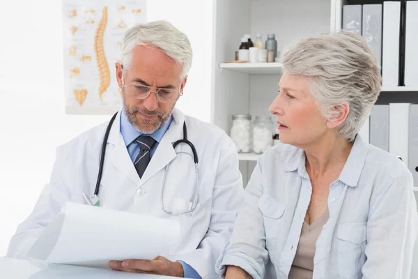 Ärztin mit Patientin liest Berichte — Stockfoto