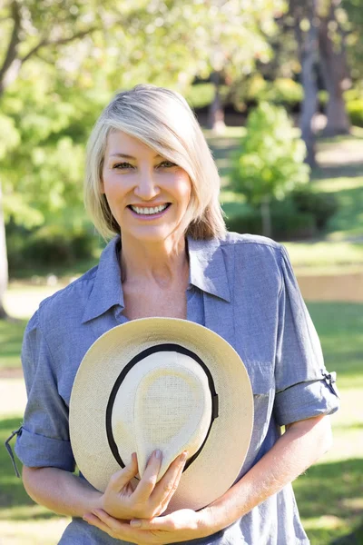 Woman holding sunhat in park — Stock Photo, Image