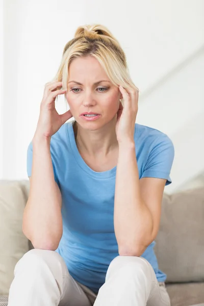 Worried woman in living room — Stock Photo, Image