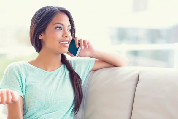 Tjej på soffan att göra ett telefonsamtal — Stockfoto