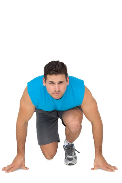 Portrait of a young sporty man in running stance — Stock Photo, Image