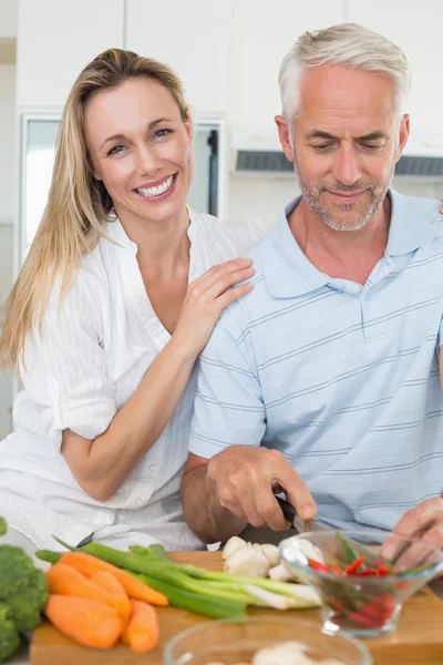 Affectionate couple preparing dinner together — Stock Photo, Image