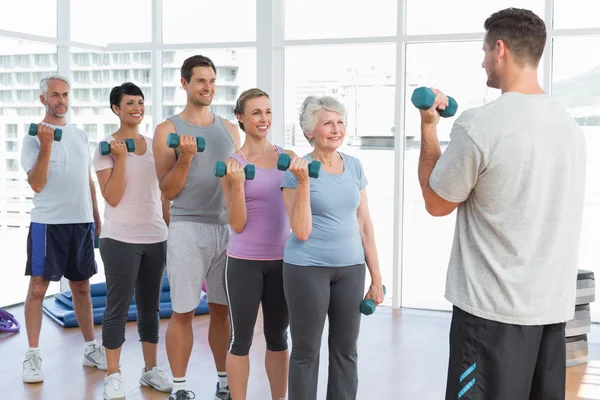 Class exercising with dumbbells in gym — Stock Photo, Image