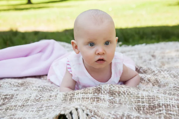 Söt baby liggande på filt på park — Stockfoto