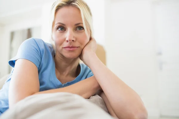 Thoughtful woman in living room — Stockfoto