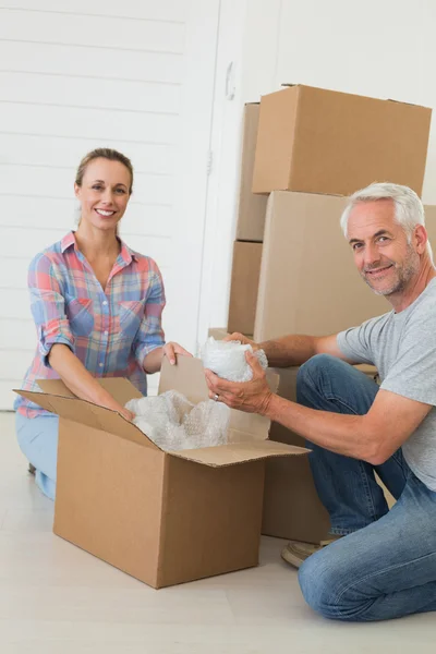 Happy couple unpacking cardboard moving boxes — Stock Photo, Image