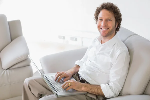 Dobrze ubrany mężczyzna korzysta z laptopa w domu — Zdjęcie stockowe