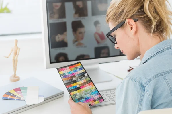 Blonde Designerin schaut auf Farbkarte — Stockfoto