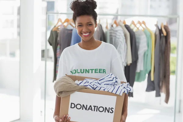 Leende ung kvinna med kläder donation — Stockfoto