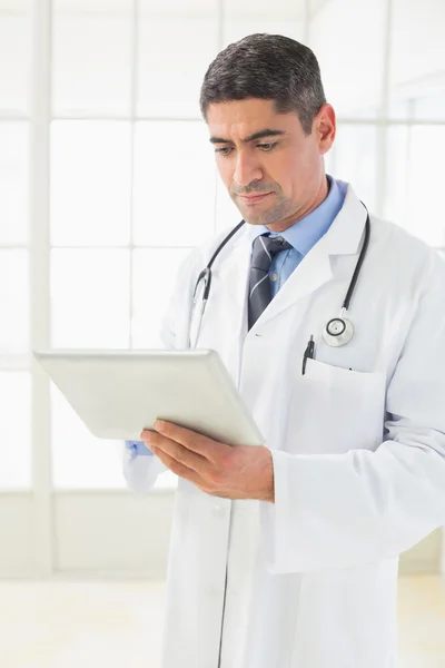 Serious male doctor using digital tablet — Stock Photo, Image