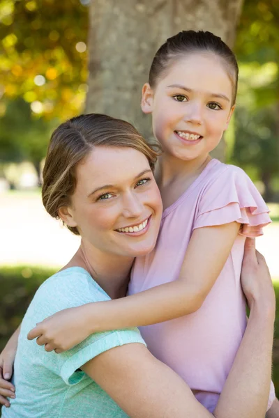 Sorridente madre che abbraccia sua figlia al parco — Foto Stock