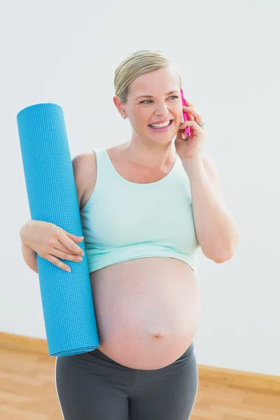 Glad gravid kvinna med träningsmatta på telefonen — Stockfoto