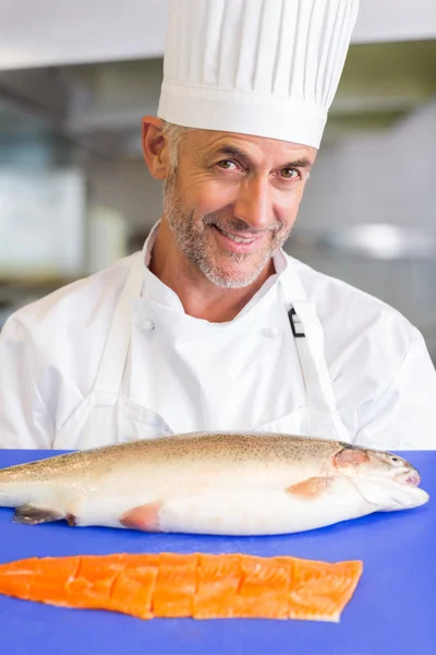 Smiling male chef holding tray of raw fish in kitchen — Stock Photo, Image
