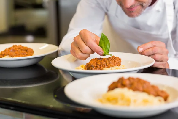 Pendekatan seorang koki laki-laki garnishing makanan — Stok Foto