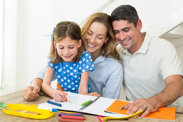 Parents looking at girl coloring — Stockfoto