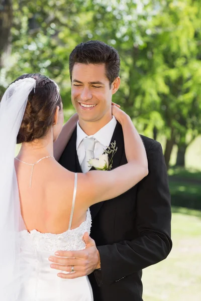 Groom embracing woman in garden — Stock Photo, Image