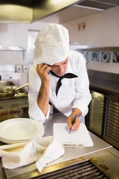 Cozinhe usando celular na cozinha — Fotografia de Stock