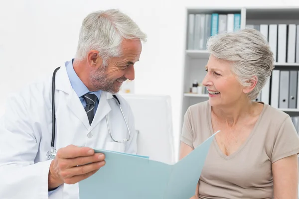 Male doctor and senior patient with reports — Stock Photo, Image